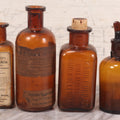 Lot 075 - Grouping Of Four Antique Amber Glass Bottles Including Cramp Bark From Sharp & Dohme, Baltimore, Sanguinaria From John Wyeth & Brother, Philadelphia, H.K. Mulford Co., Philadelphia, And One Unmarked With Stopper