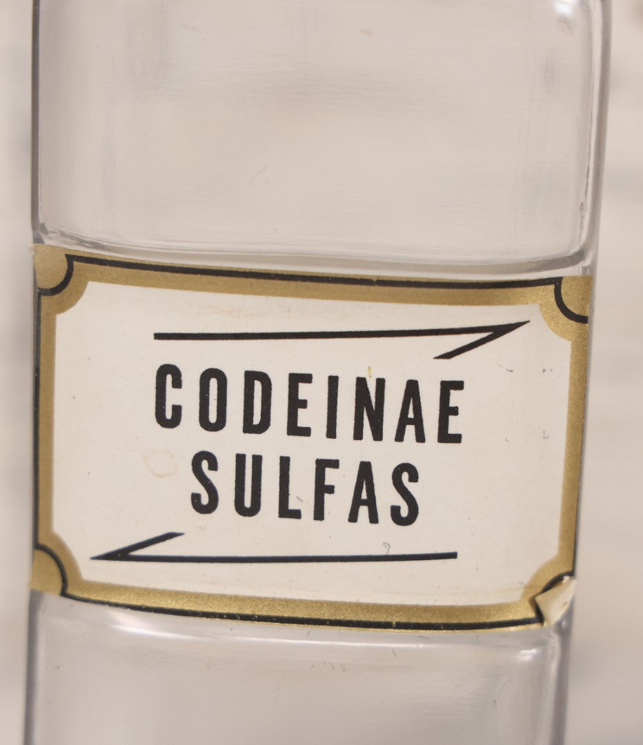 Lot 081 - Grouping Of Three Antique Clear Glass Apothecary Bottles Including Codeinae Sulfas F&S St. Louis, Bottle With Illegible Paper Label, And Otto Jafnel Pharmacist Liberty Ny