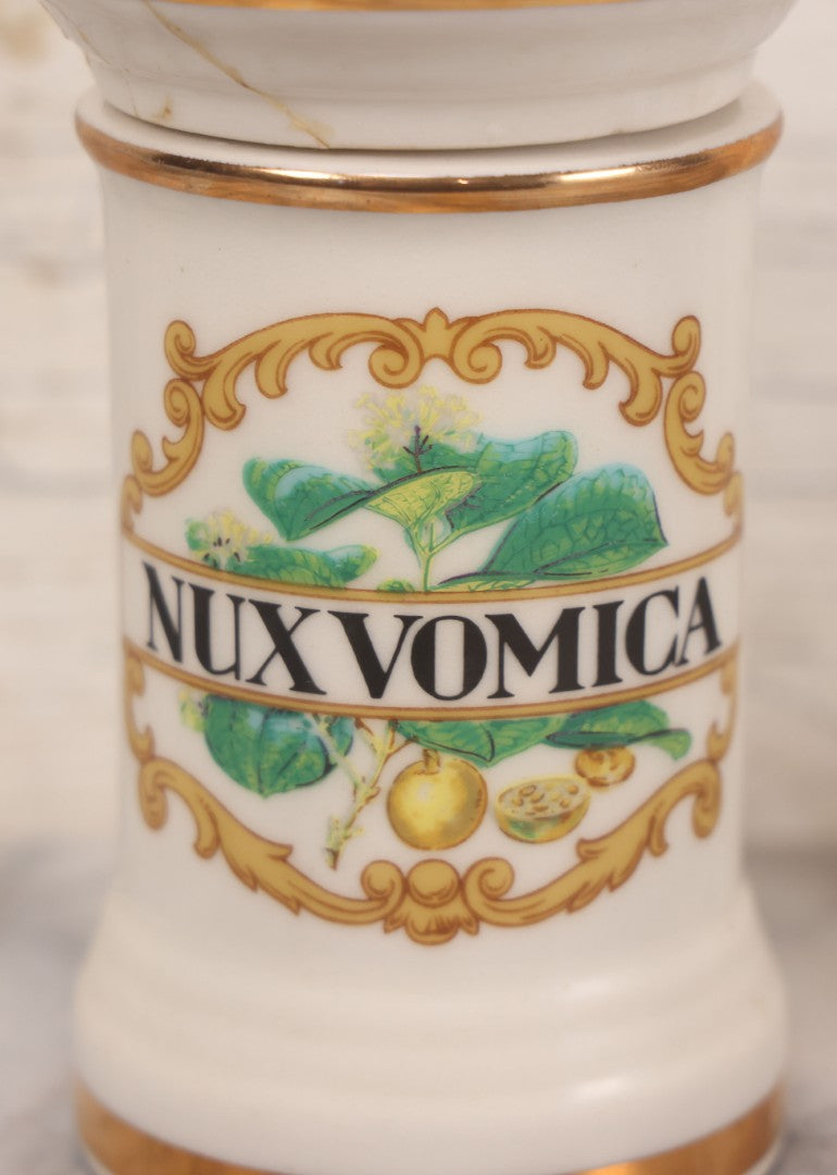 Lot 084 - Reproduction Fantasy Apothecary Jar With Lid Marked “Nux Vomica” White Opaque Pottery With Gold Painted Lines, Mid-20th Century, Bottom Marked Made In U.S.A., Note Broken And Repaired Lid, 7-5/8" H