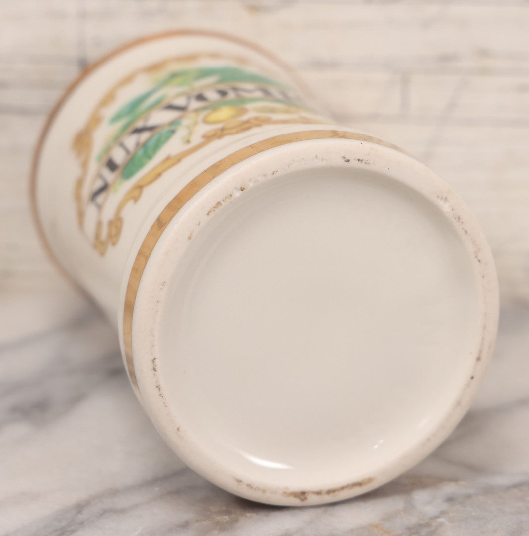 Lot 084 - Reproduction Fantasy Apothecary Jar With Lid Marked “Nux Vomica” White Opaque Pottery With Gold Painted Lines, Mid-20th Century, Bottom Marked Made In U.S.A., Note Broken And Repaired Lid, 7-5/8" H