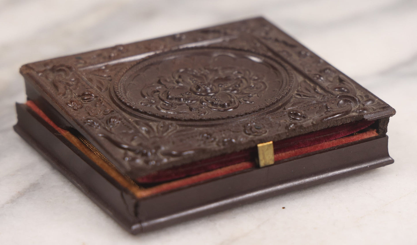 Lot 094 - Antique 1/6th Plate Daguerreotype Photograph Of Man In Full Thermoplastic Case With Abstract Floral Design, Brass Mat, Dark Red Cushion, Heavily Speckled Surface Of Photograph, Note Damage To Case