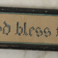 Lot 103 - Antique Small Devotional Punchwork Embroidery “God Bless Thee” In Two-Tone Blue Thread, In Metal Frame Behind Glass, 5-1/2" x 1-3/4"