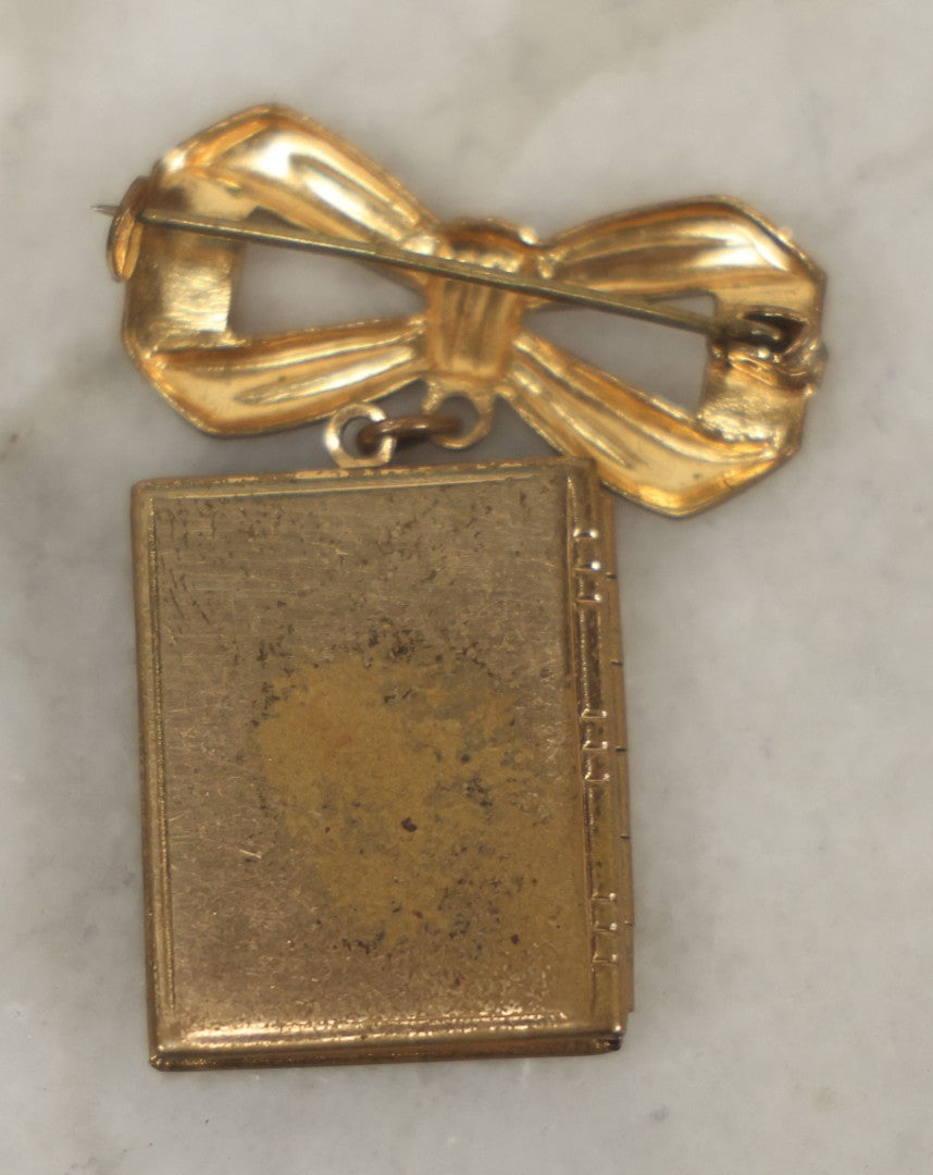 Lot 123 - Vintage Gold-Tone Bow Brooch With Dangling Book-Form Locket Monogrammed “M & B”