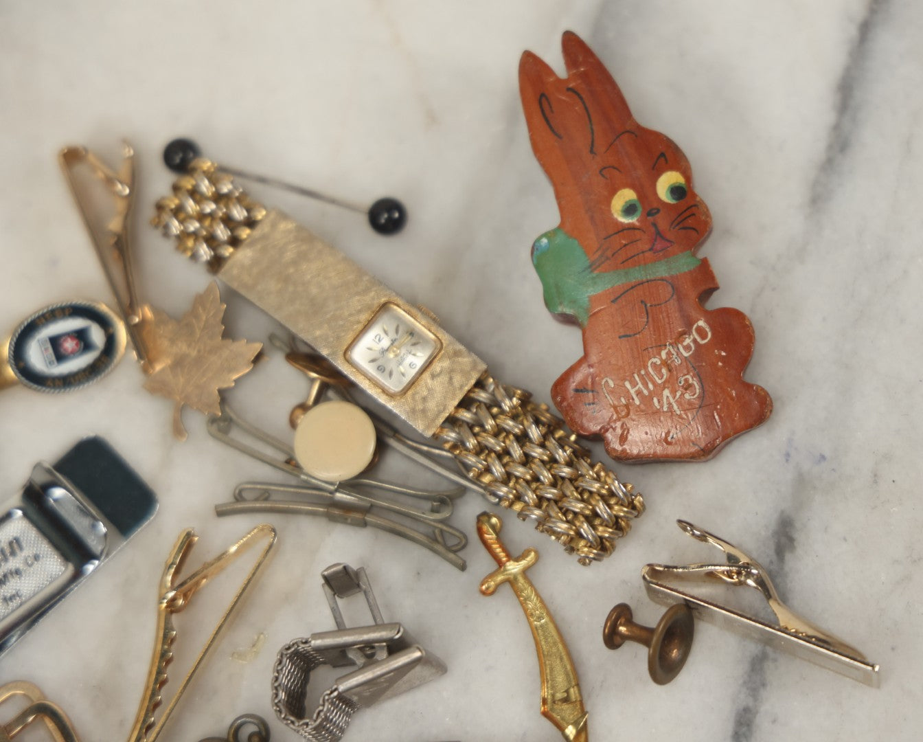 Lot 125 - Grouping Of 10+ Vintage Junk Drawer Items Including Jewelry, Pins, Tie Bars, And Wooden Bunny Chicago 1943 Pin