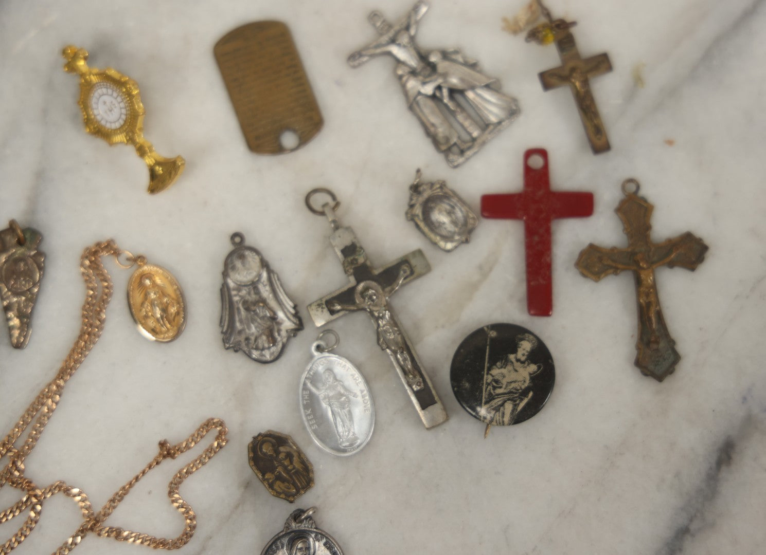 Lot 126 - Grouping Of 10+ Vintage Religious Items Including Crucifixes, Charms, “Our Father” Dog Tag, Pinback Button, And More