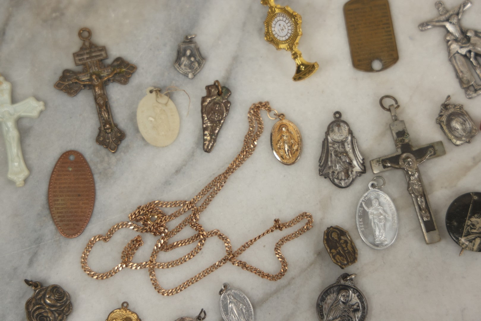 Lot 126 - Grouping Of 10+ Vintage Religious Items Including Crucifixes, Charms, “Our Father” Dog Tag, Pinback Button, And More