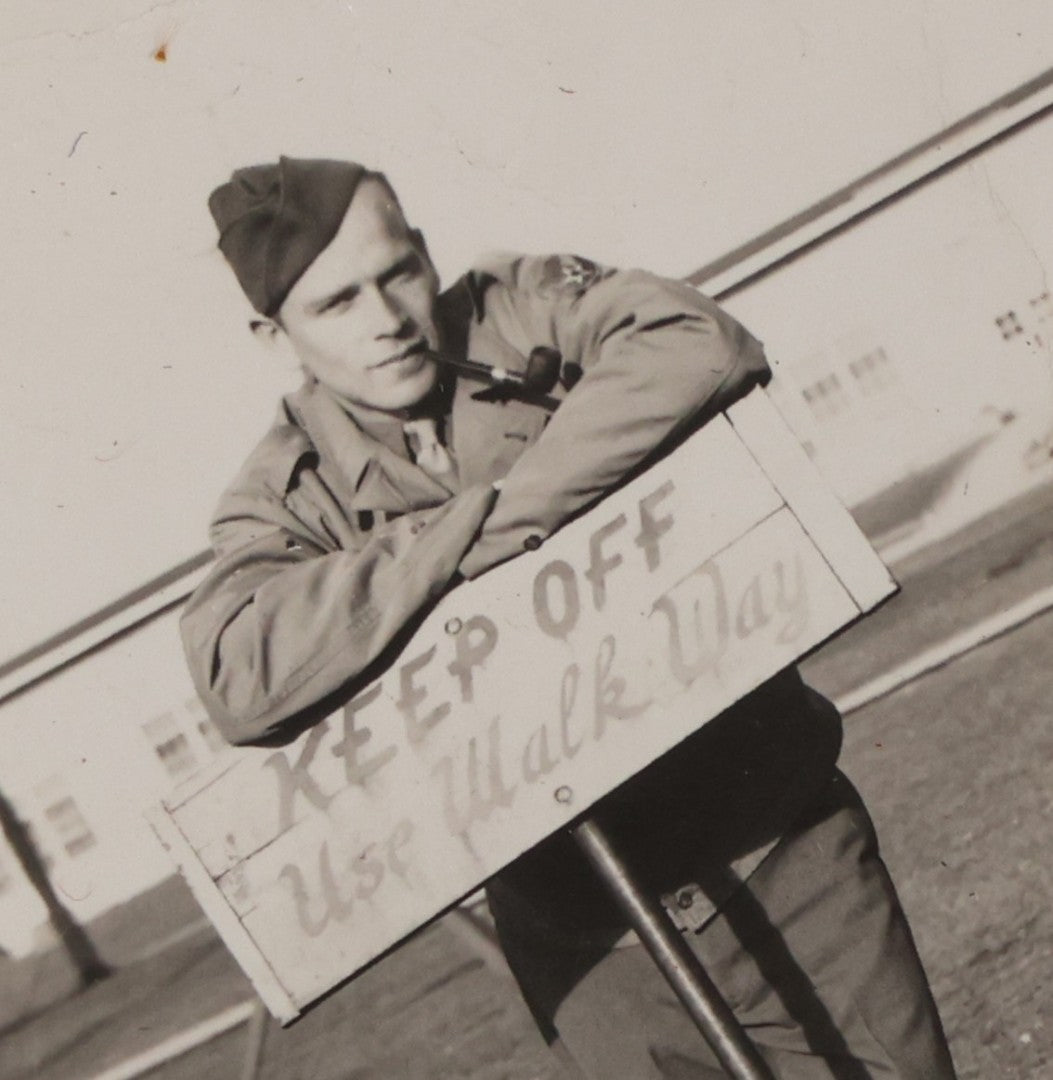 Lot 195 - Vintage Snapshot Photograph Of Soldier Smoking Pipe Leaning On (And Disobeying) "Keep Off / Use Walkway" Sign