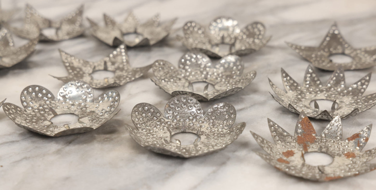 Lot 198 - Grouping Of 16 Pressed Tin Candle Wax Drip Holders In Starburst, Flower, And Star Designs