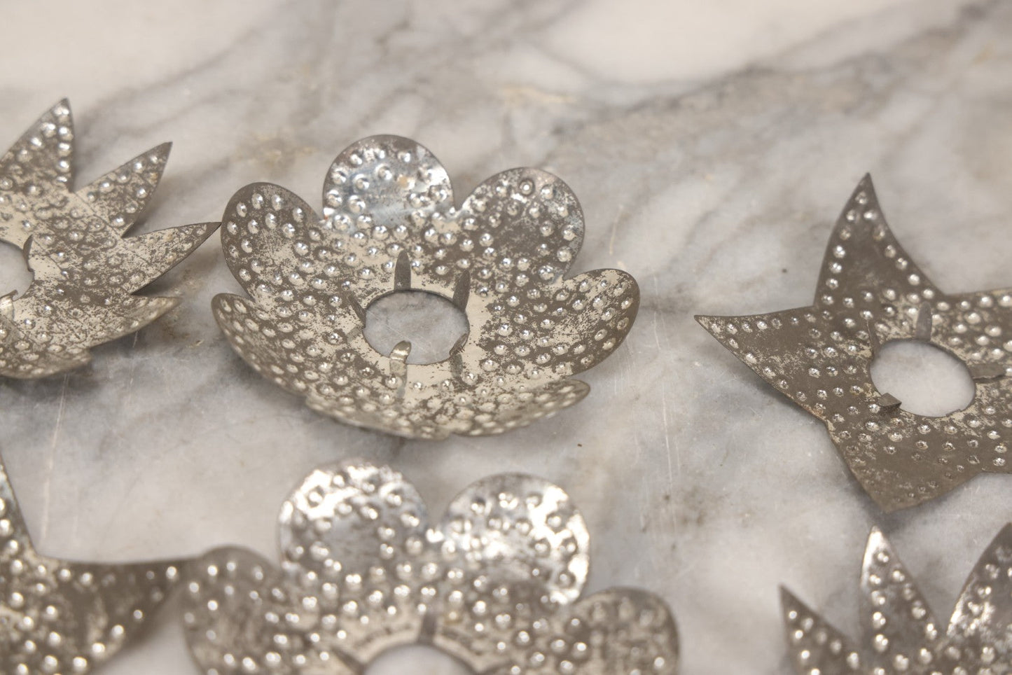 Lot 198 - Grouping Of 16 Pressed Tin Candle Wax Drip Holders In Starburst, Flower, And Star Designs