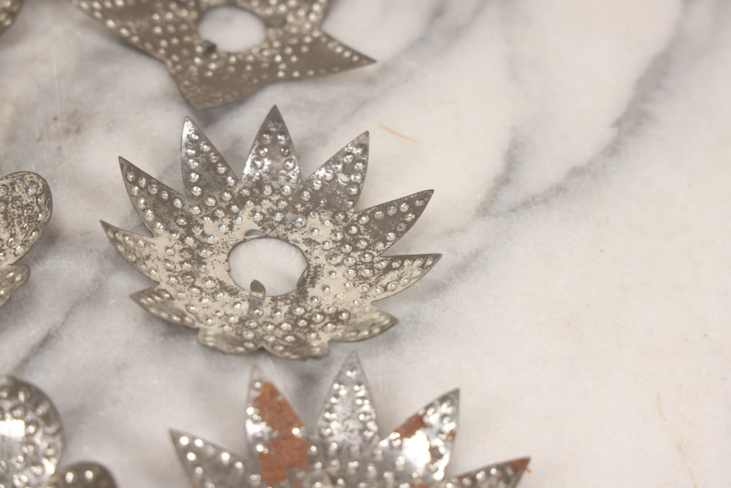 Lot 198 - Grouping Of 16 Pressed Tin Candle Wax Drip Holders In Starburst, Flower, And Star Designs