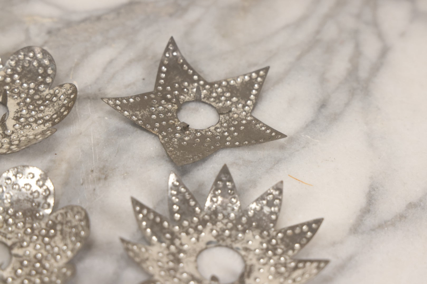 Lot 198 - Grouping Of 16 Pressed Tin Candle Wax Drip Holders In Starburst, Flower, And Star Designs