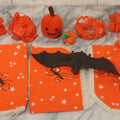 Lot 090 - Grouping Of Halloween Toys And Crafts, Including Rubber Bat, Stuffed Knit Pumpkin, Three Painted Spider Placemats, Four Jack-O-Lantern Cellophane Garlands, And Google-Eyed Jack-O-Lantern Pin Cushion