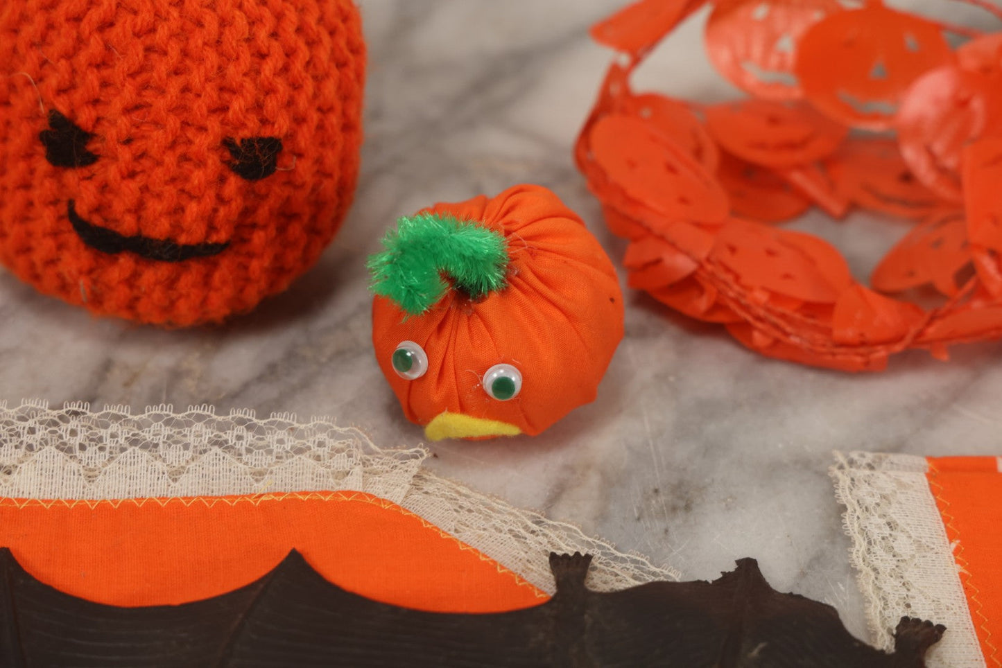 Lot 090 - Grouping Of Hallowe'en Toys And Crafts, Including Rubber Bat, Stuffed Knit Pumpkin, Three Painted Spider Placemats, Four Jack-O-Lantern Cellophane Garlands, And Google-Eyed Jack-O-Lantern Pin Cushion
