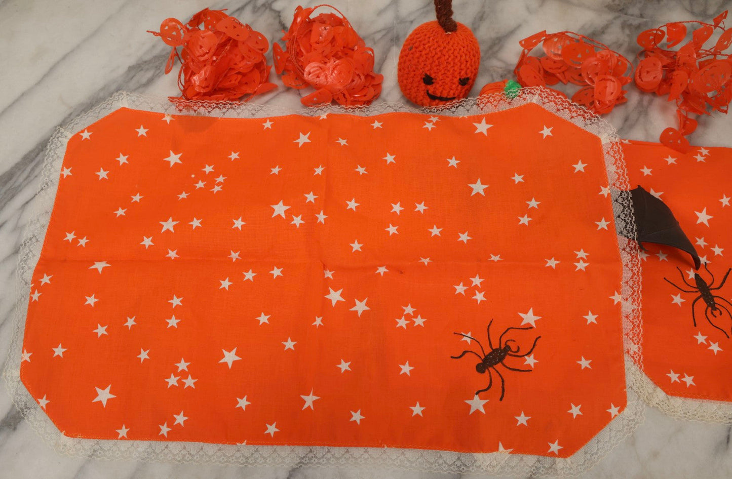 Lot 090 - Grouping Of Hallowe'en Toys And Crafts, Including Rubber Bat, Stuffed Knit Pumpkin, Three Painted Spider Placemats, Four Jack-O-Lantern Cellophane Garlands, And Google-Eyed Jack-O-Lantern Pin Cushion