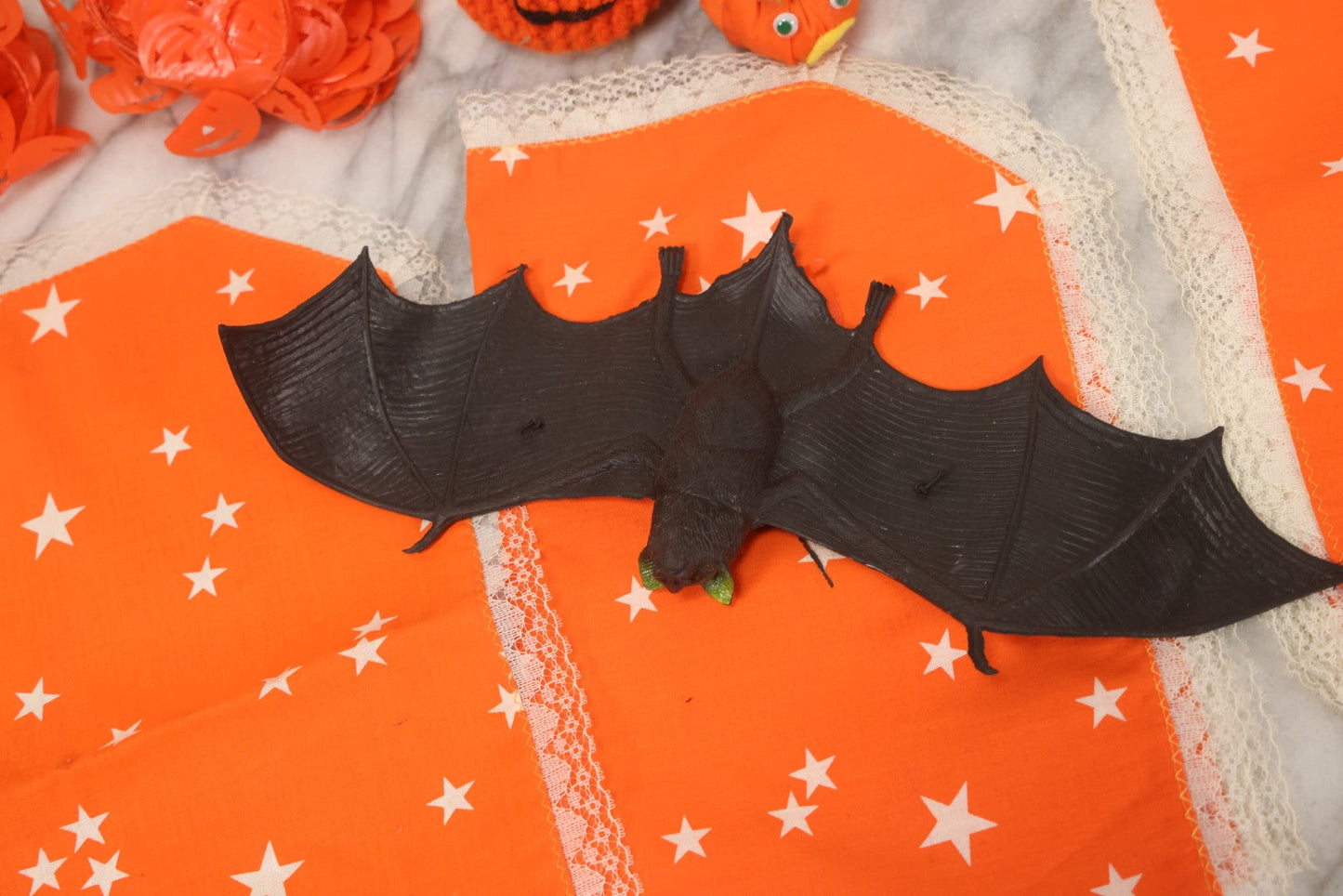 Lot 090 - Grouping Of Hallowe'en Toys And Crafts, Including Rubber Bat, Stuffed Knit Pumpkin, Three Painted Spider Placemats, Four Jack-O-Lantern Cellophane Garlands, And Google-Eyed Jack-O-Lantern Pin Cushion