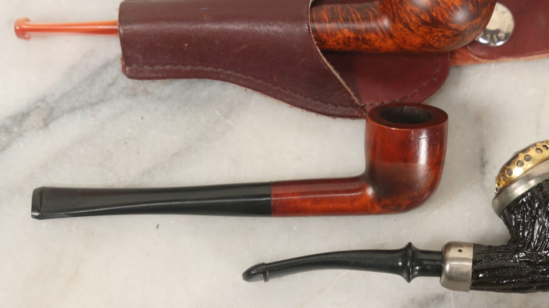 Lot 099 - Grouping Of Three Vintage Pipes Including Genuine Briar, Wood Grain With Sheath, And Painted Wood With Brass Cover