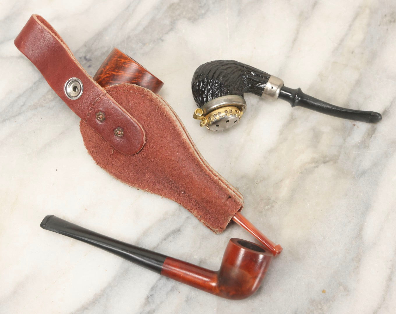 Lot 099 - Grouping Of Three Vintage Pipes Including Genuine Briar, Wood Grain With Sheath, And Painted Wood With Brass Cover