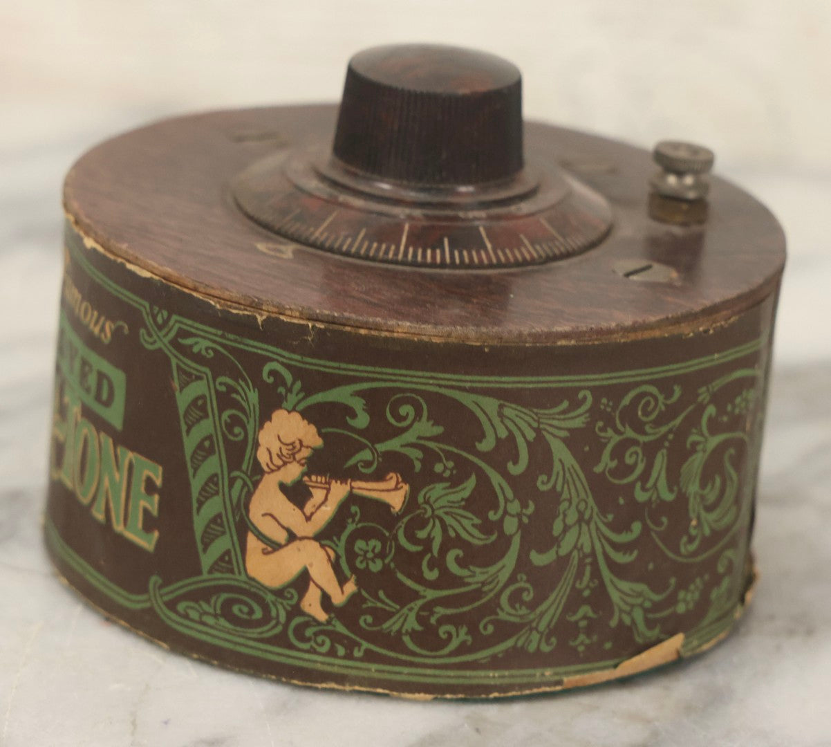 Lot 103 - Antique "The Famous Improved Kleer-Tone" Radio Tuner Variable Capacitor With Bakelite Knob And Cherub Motif Paper Wrap, 1920s