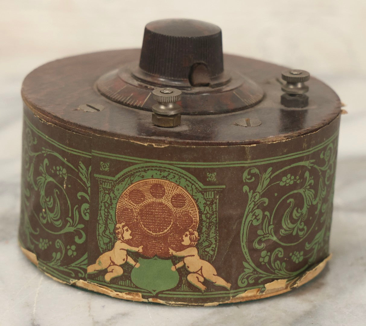 Lot 103 - Antique "The Famous Improved Kleer-Tone" Radio Tuner Variable Capacitor With Bakelite Knob And Cherub Motif Paper Wrap, 1920s