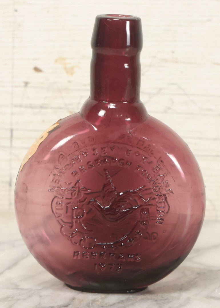Lot 114 - Vintage Odd Fellows And Rebekah Commemorative Purple Glass Bottle, “New Jersey Eye Bank Visual Research Foundation,” 1973, With All-Seeing-Eye And F.L.T. Three Links, Clevenger Bros. Glass Works, Clayton, New Jersey, 7" H