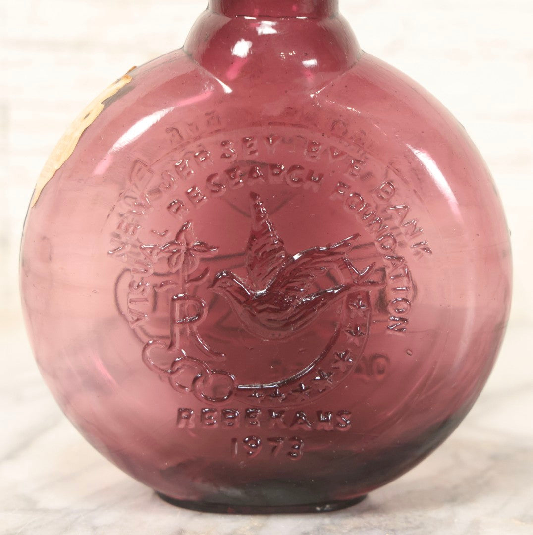 Lot 114 - Vintage Odd Fellows And Rebekah Commemorative Purple Glass Bottle, “New Jersey Eye Bank Visual Research Foundation,” 1973, With All-Seeing-Eye And F.L.T. Three Links, Clevenger Bros. Glass Works, Clayton, New Jersey, 7" H
