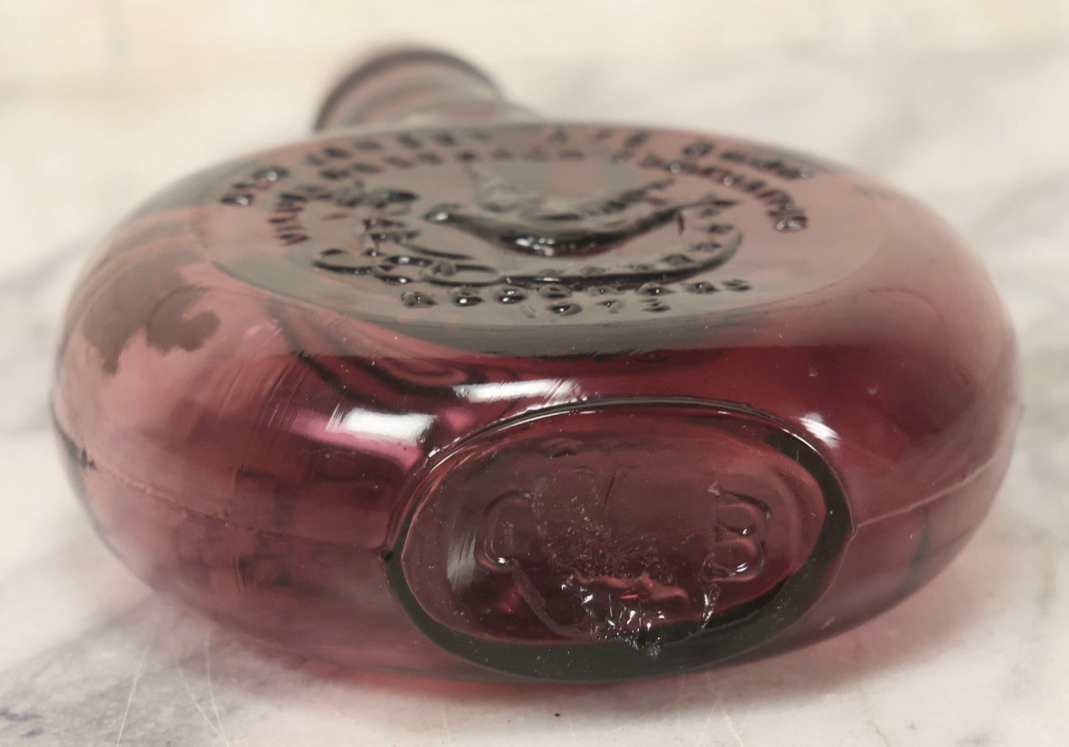 Lot 114 - Vintage Odd Fellows And Rebekah Commemorative Purple Glass Bottle, “New Jersey Eye Bank Visual Research Foundation,” 1973, With All-Seeing-Eye And F.L.T. Three Links, Clevenger Bros. Glass Works, Clayton, New Jersey, 7" H
