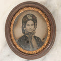 Lot 164 - Antique Oval-Cut Tintype Photograph Of Woman In Bonnet With Flowers And Bow Scarf, In Brown Thermoplastic “Oreo”-Style Case With Brass Preserver, 1-7/8" x 2-1/8"