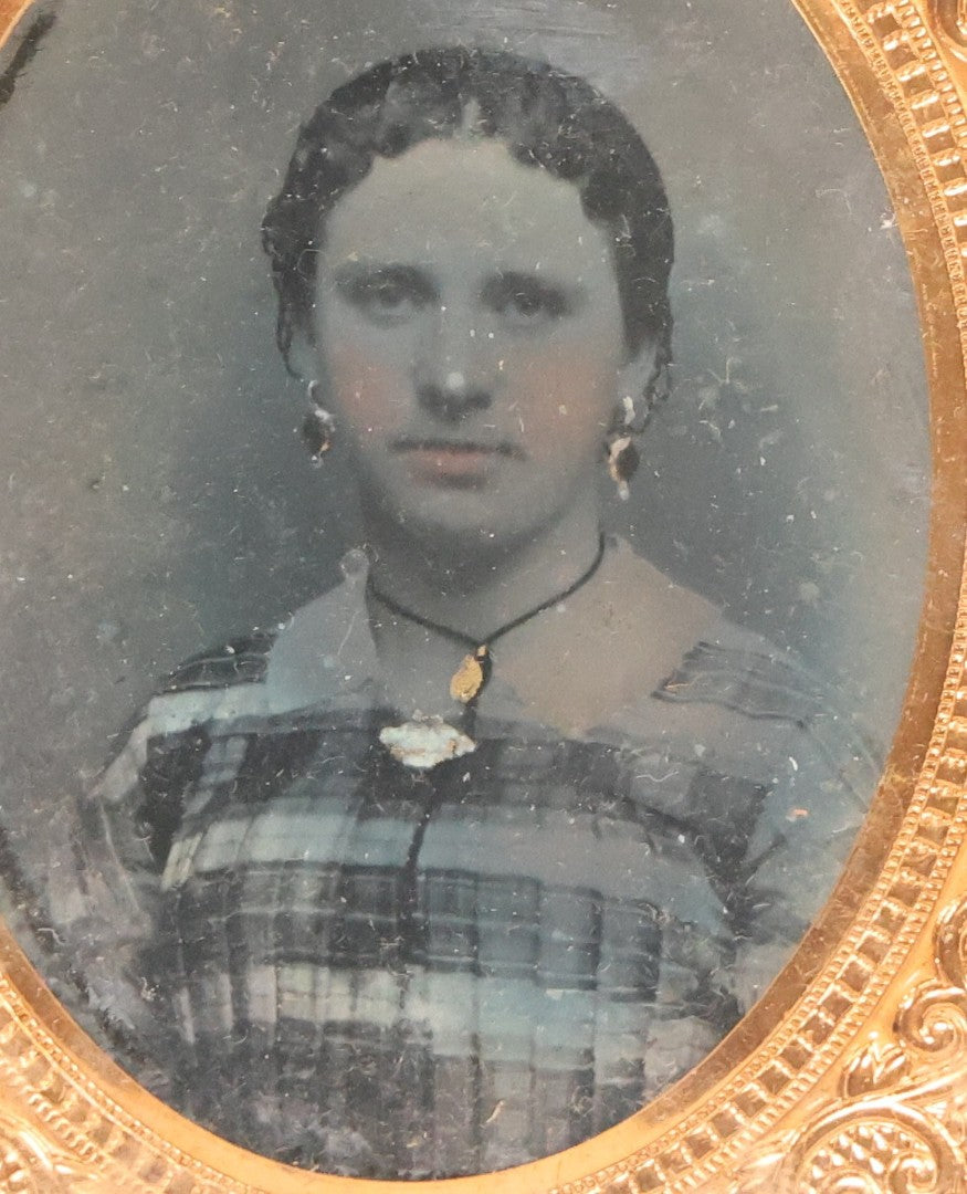 Lot 165 - Grouping Of Three Antique Portrait Photographs, One Tintype Of A Young Man, Two Ruby Ambrotypes In Brass Mats Including Young Woman With Hand-Painted Jewelry And Young Man In Bowtie