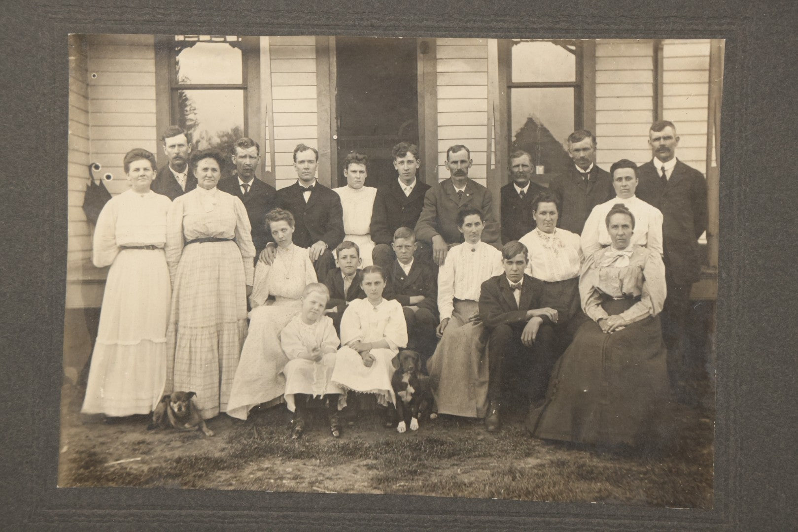 Lot 171 - Antique Boarded Group Family Photograph Of Three Generations Posed On Steps Of House With Two Dogs
