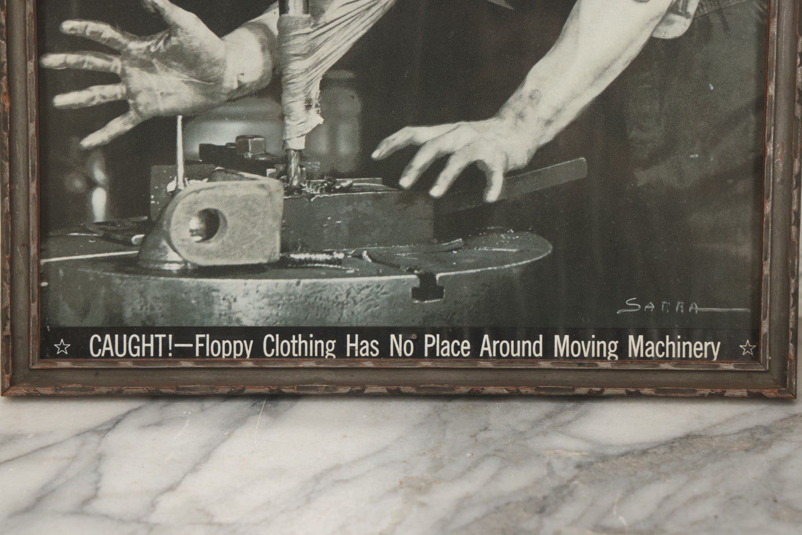 Lot 233 - Vintage Industrial Safety Photograph “Caught!—Floppy Clothing Has No Place Around Moving Machinery,” Signed Sarra, In Gray Painted Frame, 11-1/8" x 12-1/8"