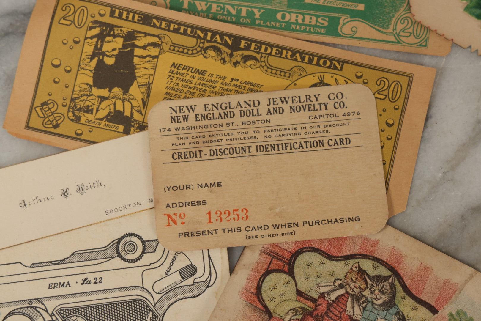 Lot 242 - Grouping Of 15 Antique And Vintage Mixed Ephemera Scraps Including Novelty Space Money From Neptune, 1882 Award Of Merit, Hand Motif Calling Cards, New England Jewelry Co. Coupon, Cat Booklet, Yellowstone Decal, And Erma EP22 Pistol Booklet