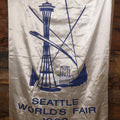 Lot 264 - Vintage Seattle World's Fair 1962 Nylon Flag Banner With Screen Printed Blue Graphics On White Field Featuring Space Needle And Other Landmarks, Yellow Fringe, Manufactured By Paramount Flag Co., San Francisco, California, 40-1/2" x 61-1/2"