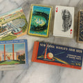 Lot 266 - Grouping Of Three Vintage New York World's Fair 1939 Souvenirs Including Used Ticket Book, Complete Deck Of Playing Cards In Gold Foil Box, Ford Motor Company Building Postcard, And Hall Of Communications Postcard