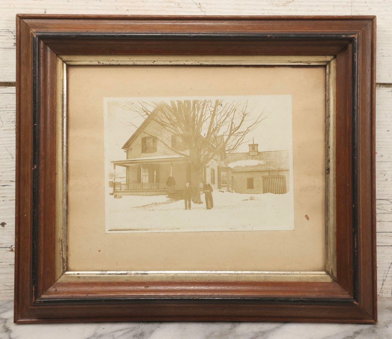 Lot 111 - Antique Boarded Photograph Of Elderly Couple And Older Woman Before New England Connected Farmhouse And Barn In Winter, In Walnut Double Frame, 13-1/4" x 11-3/8"