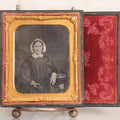 Lot 047 - Antique 1/6th Plate Ruby Ambrotype Photograph Of Elderly Woman In White Bonnet Holding Object, Possibly A Book, In Full Split Leatherette Union Case
