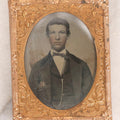 Lot 061 - Antique 1/9th Plate Hand-Tinted Tintype Photograph Of Thin Young Man With Bowtie And Vest Chain, Uncased With Brass Mat And Preserver