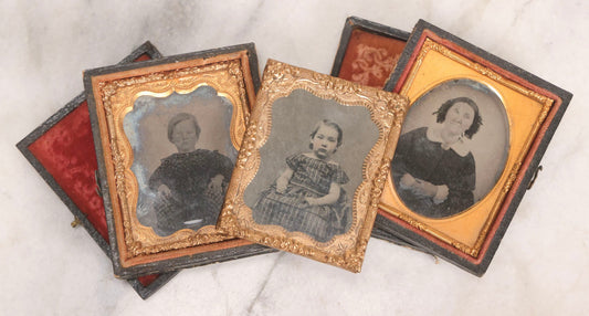 Lot 062 - Trio Of Antique 1/9th Plate Ruby Ambrotype Photographs Including Little Girl In Dress, Elderly Woman With Tied-Back Curls, And Stoic Little Boy, In Mixed Cases