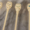 Lot 095 - Grouping Of Four Vintage Molded Plastic Skull-And-Bone Swizzle Stick Cocktail Stirrers With Rhinestone Eyes, Circa 1950s–1960s 6-3/4" L Each