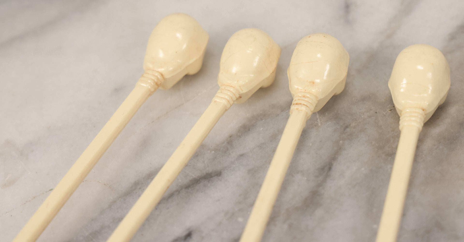 Lot 095 - Grouping Of Four Vintage Molded Plastic Skull-And-Bone Swizzle Stick Cocktail Stirrers With Rhinestone Eyes, Circa 1950s–1960s 6-3/4" L Each