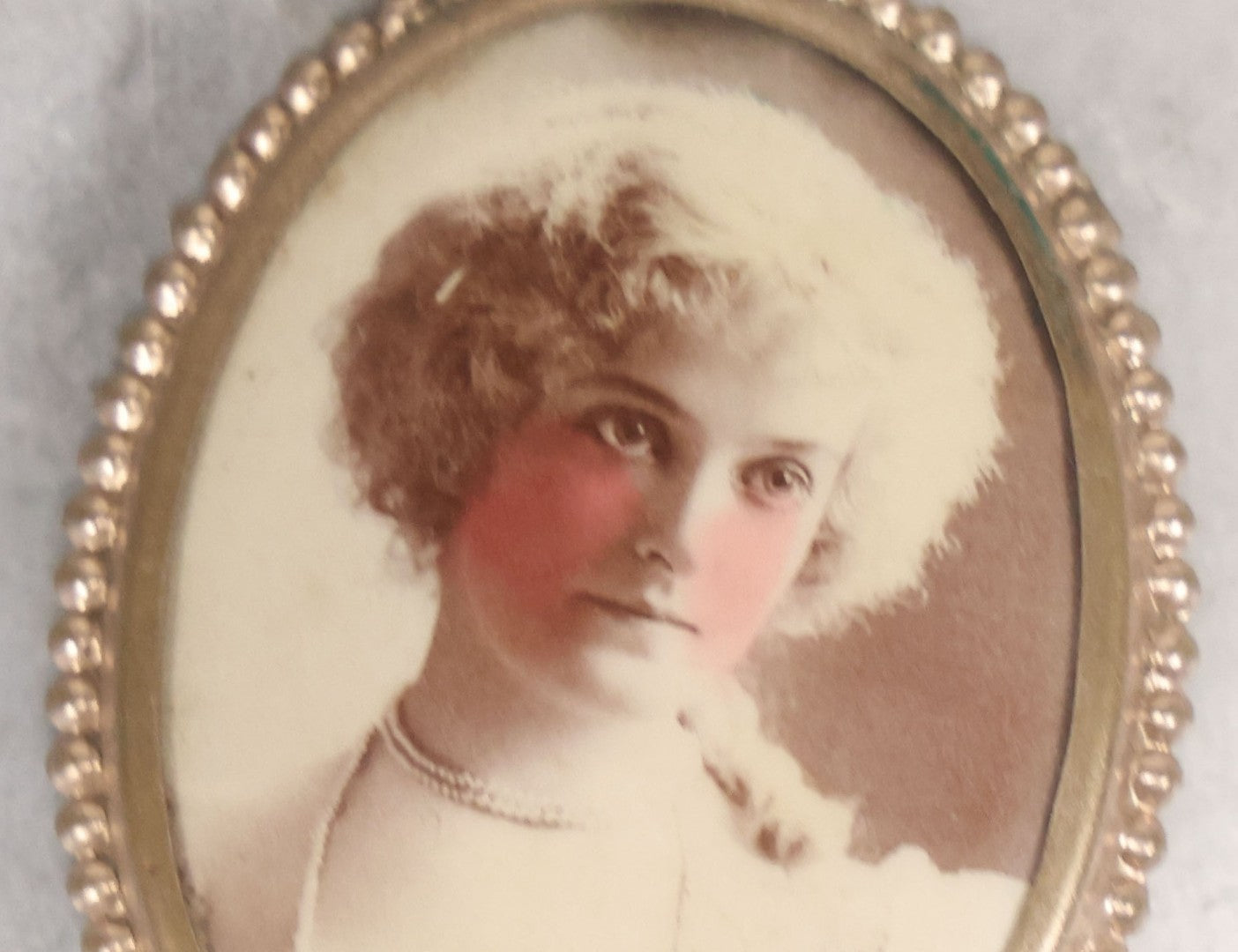 Lot 133 - Antique Celluloid Portrait Brooch With Hand-Tinted Photograph Of Young Woman With Rosy Cheeks In Brass Bezel