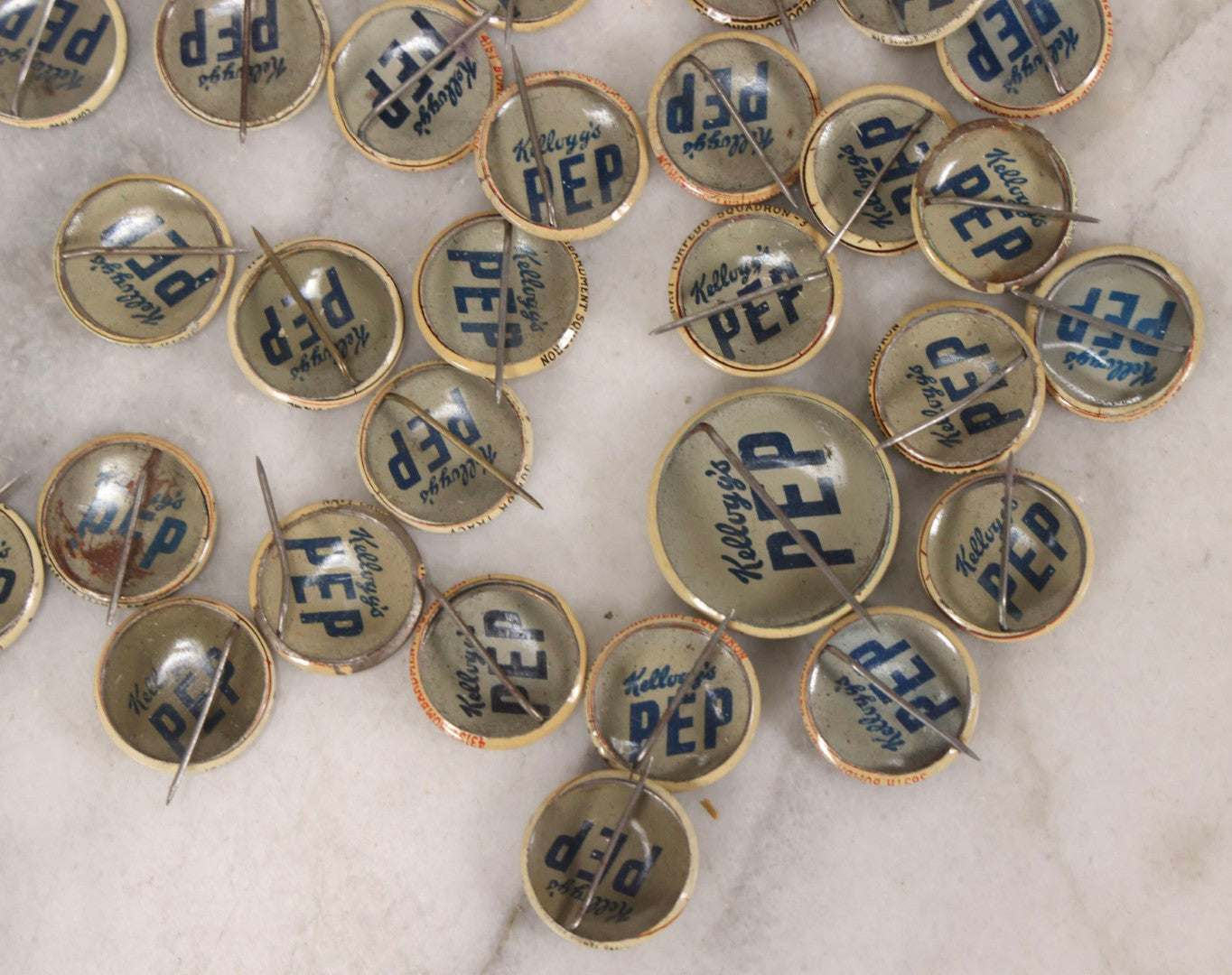 Lot 187 - Grouping Of 30 Vintage Kellogg's Pep Cereal Pinback Buttons Featuring Comic Strip Characters Like Popeye And Lord Pushbottom And World War II Military Insignia, Copyright 1946