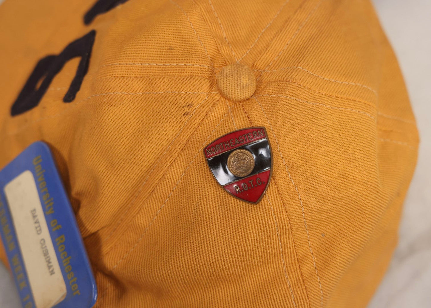 Lot 085 - Vintage Orange Cap With “65” Patch, E. Rosenstein Sons Label, And Two University Pins