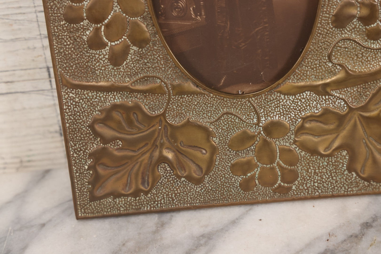 Lot 138 - Antique Hammered Brass Photo Frame With Grapes And Grape Leaves Motif, Missing Stand, 8-1/8" x 10"