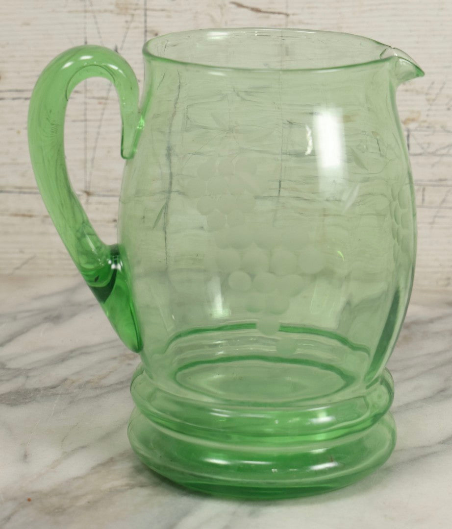 Lot 022 - Antique Uranium Glass Pitcher With Etched Grape Motif, Glows Under Blacklight, Note Chip On Spout