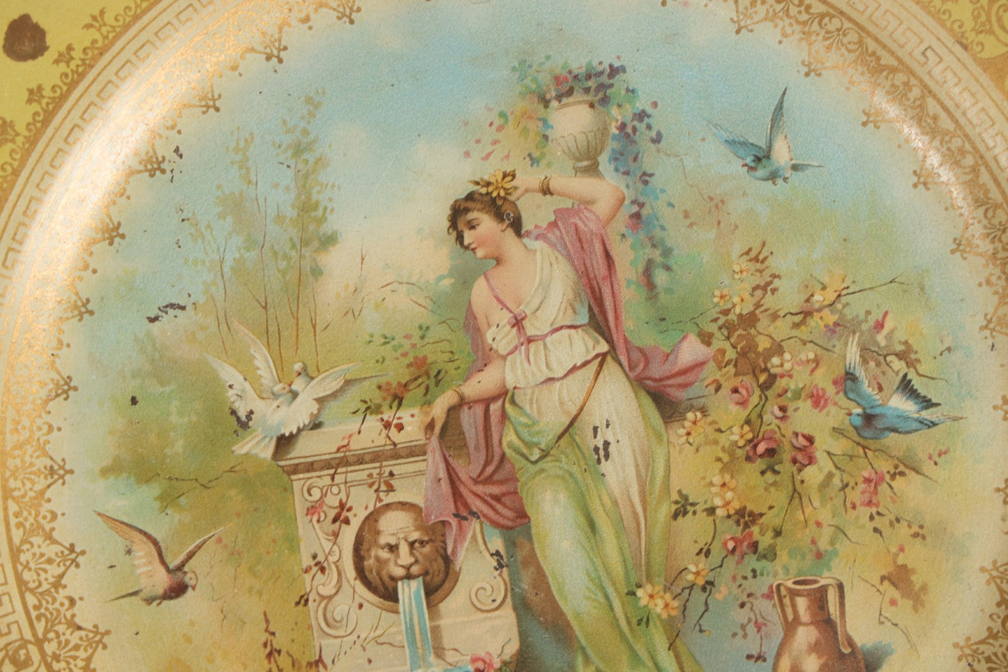 Lot 049 - Antique Vienna Art Plates Tin Lithograph Decorative Plate With Classical Maiden, Birds, And Floral Motifs, Marked “Vienna Art Plates, Patent Applied For”
