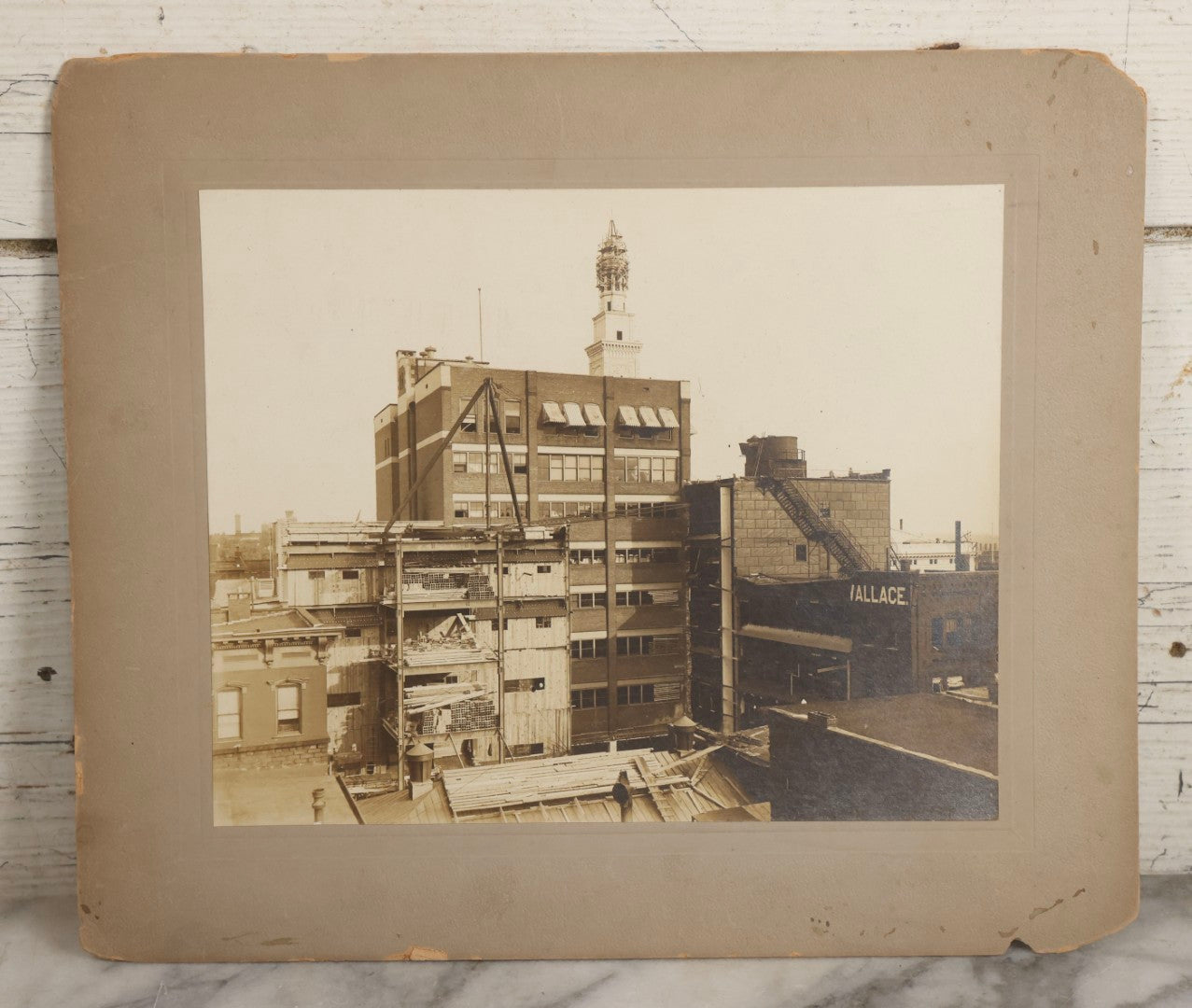 Lot 140 - Antique Boarded Photograph Of Urban Construction Scene With Multi-Story Buildings, Rooftop Water Tank, And “Wallace” Sign Visible