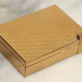 Lot 059 - Vintage Volupte Brass Makeup Compact With Pull-Out Lipstick Holder And Wind Up Musical Box, Made In U.S.A..