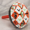 Lot 048 - Vintage Round Halloween Tin Lithograph Noisemaker With Orange And White Checkered Pattern Featuring Black Cat, Witch, Ghost, Bat, Skull, And Jack-O'-Lantern J.O.L. Characters
