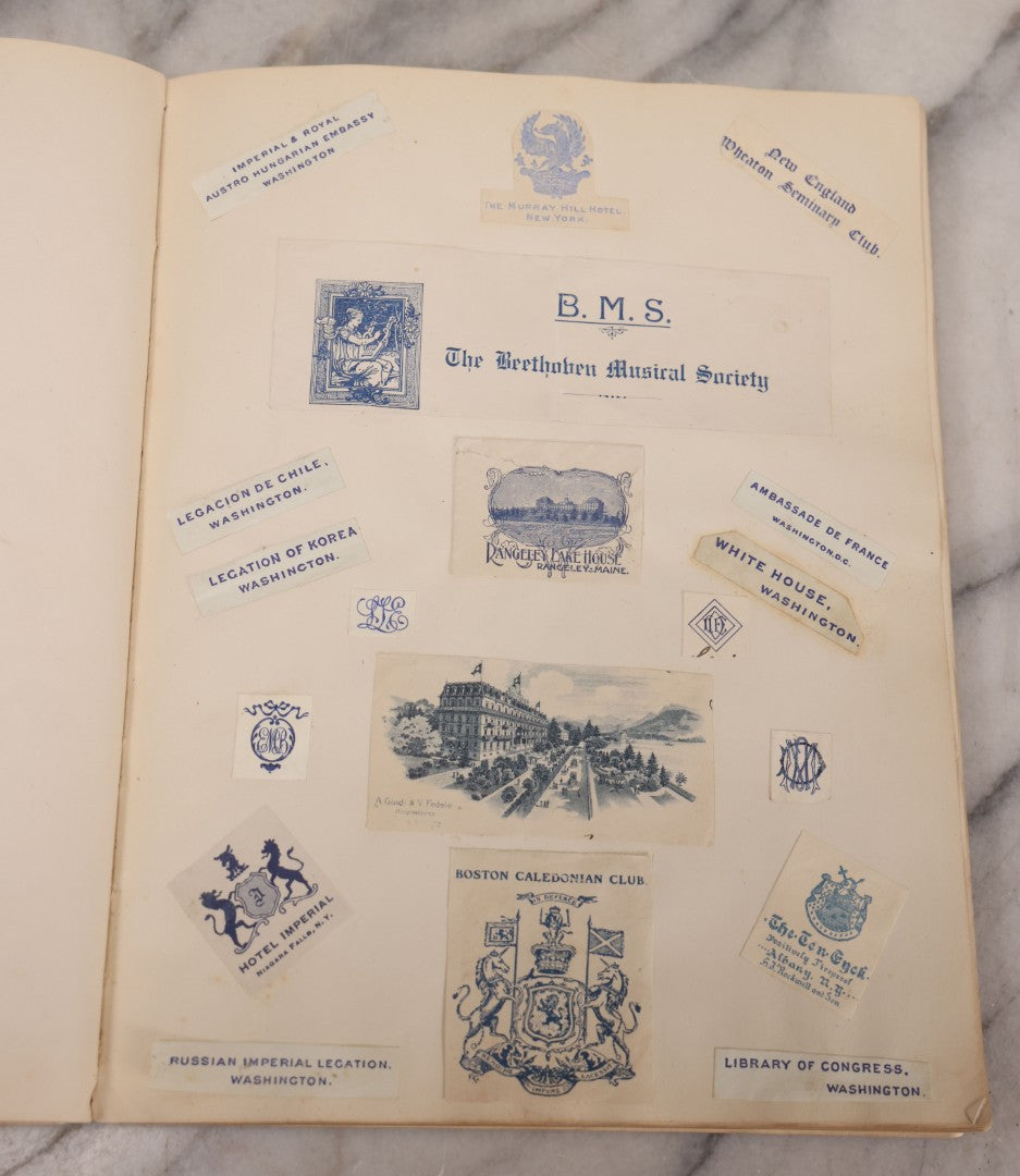 Lot 294 - Antique Scrapbook With Clipped Logos, Seals, And Institutional Names From Colleges, Hotels, Clubs, Banks, Government Offices, And More, Arranged By Color Throughout 20+ Pages, Marbled Cover Boards