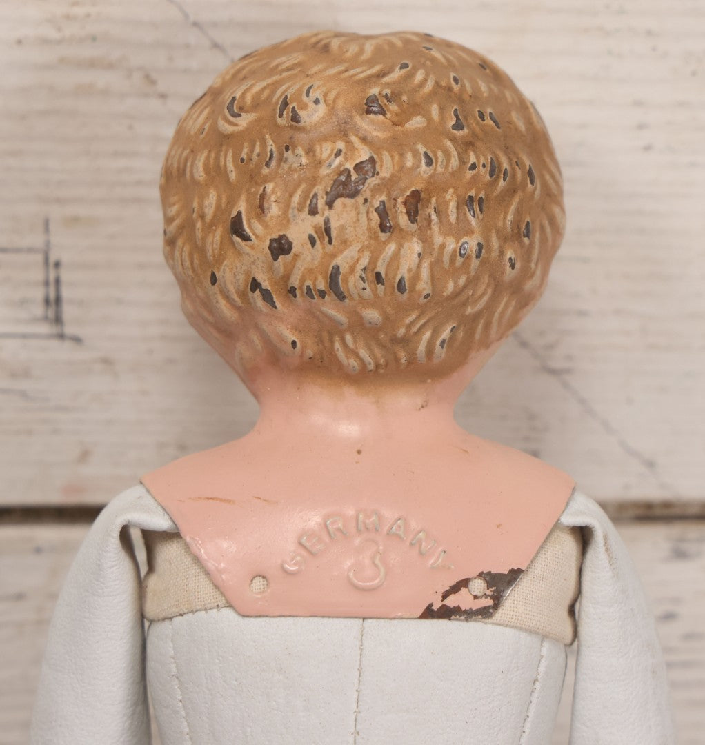 Lot 084 - Antique German Minerva Metal Head Doll With Molded Blonde Hair And Painted Features, Cloth And Leather Body, Circa 1900s-1920s 12" H